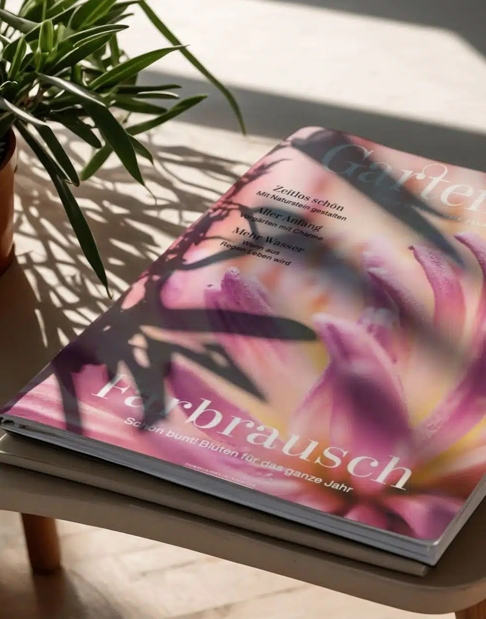 Teaserbild_GatrenArt_980x1251 Cover des GartenArt Magazins mit einer Hand und Pflanzenmotiven in verschiedenen Farben.